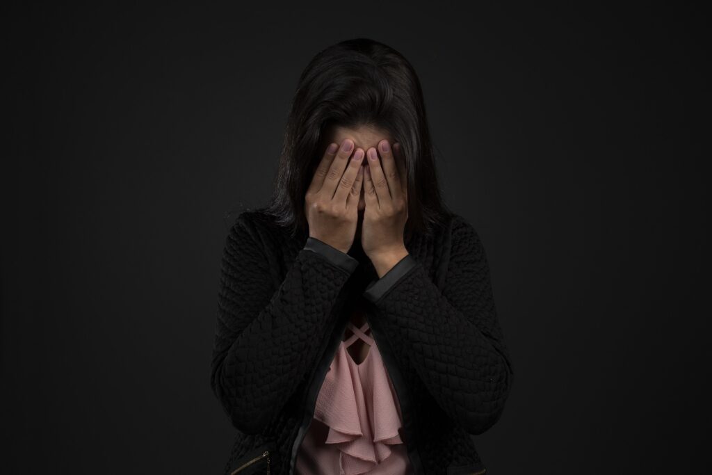 woman with head in her hands feeling overwhelmed