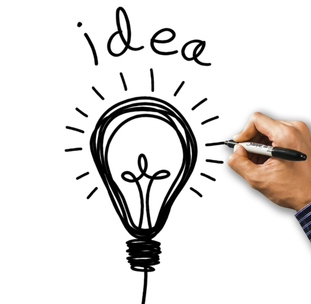 hand with pen drawing a light bulb with idea written above it