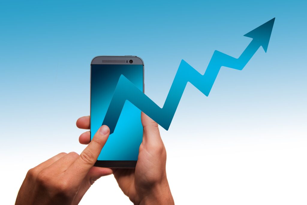hands holding a mobile phone with a blue arrow going upwards coming out of the phone