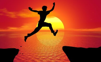 person leaping in the air at sunset