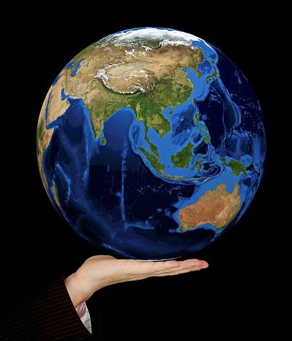 person holding globe in their hand