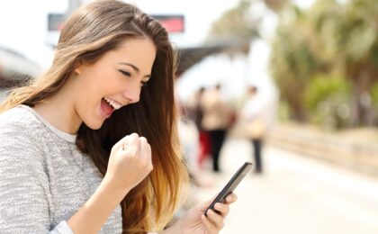 excited woman looking at her mobile phone