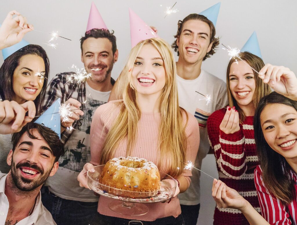 group celebrating with party hats and cake