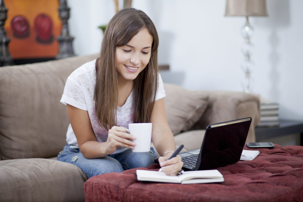 e-learning student writing about 5 profitable online course models whilst drinking coffee