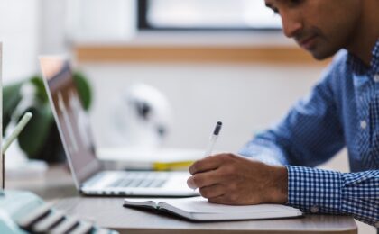 man sitting at desk writing tips for creating compelling content
