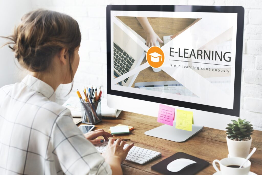 woman sitting at computer interested in e-learning and reading about 5 profitable online course models