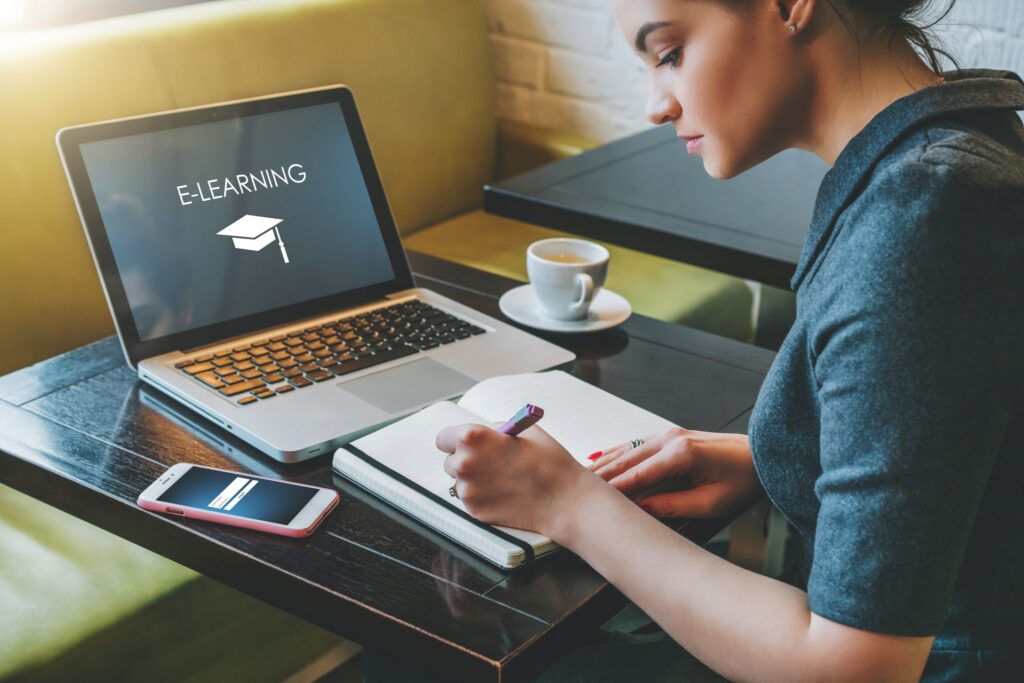 e-learning student sitting in a cafe working on 5 profitable online course models