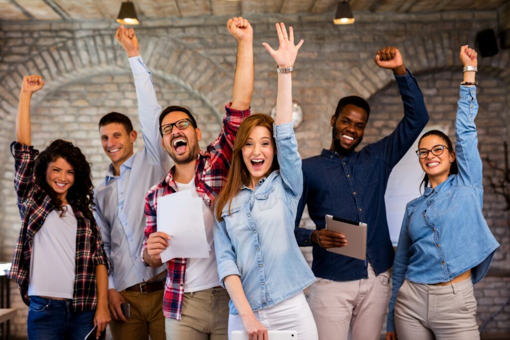 enthusiastic group of people with their arms in the air having learnt how to grow their list with content curation and repurposing