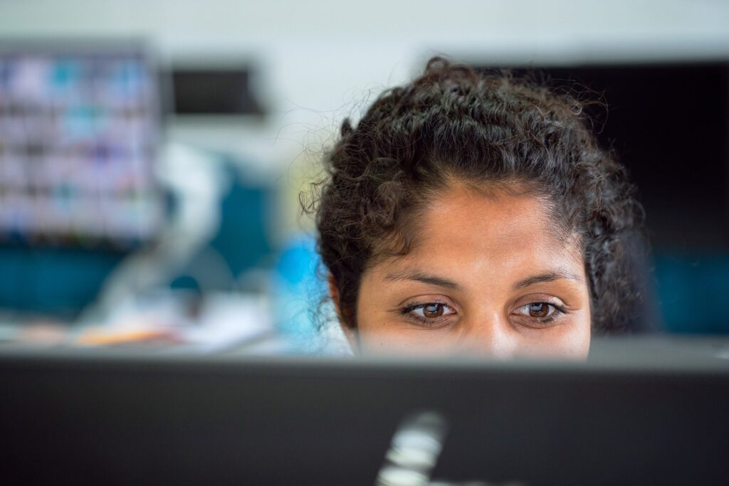 woman looking at hiring outsourcers and on websites on a computer and building herself a better business