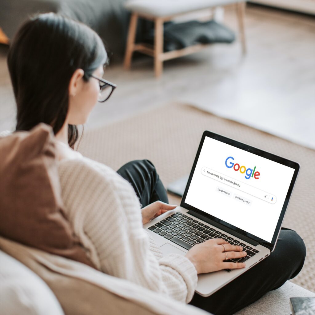 girl wearing glasses searching on Google on laptop for the role of title tags in website ranking information