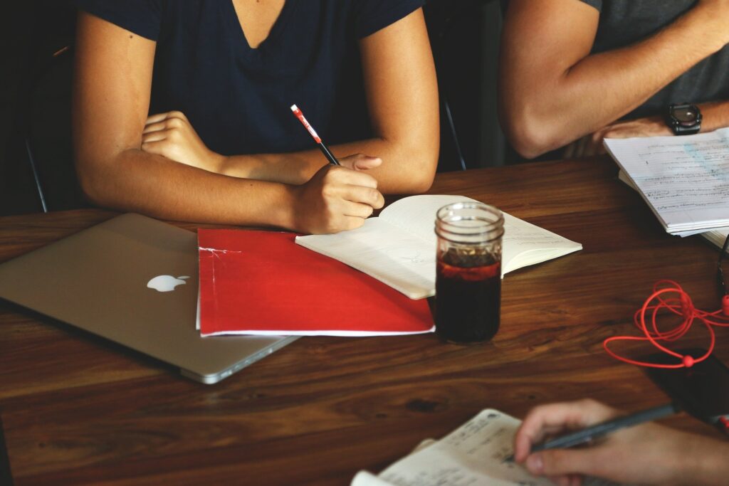 person sitting at table writing down the 7 tips that make marketing your business easier