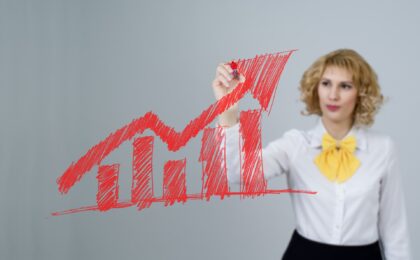 woman using red marker on a chart to show boost in sales