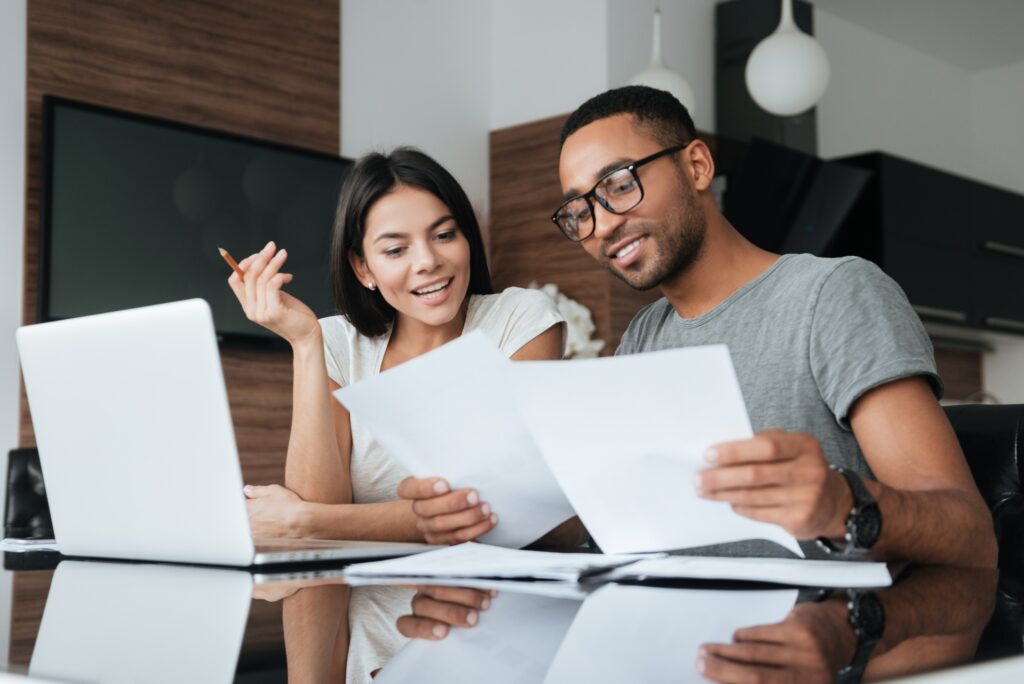couple sitting at desk with laptop and paperwork reading the importance of content for your website and social media blog post