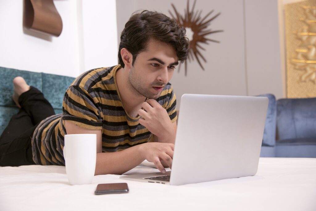 man focused on his laptop reading blog on make your business more personal and interesting with a blog 
