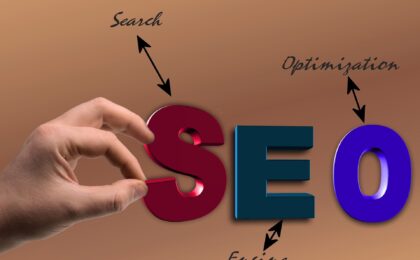 5 Easy Tips to Optimize Your WordPress Website featured image. SEO displayed in colourful letters with a hand pinching the S.